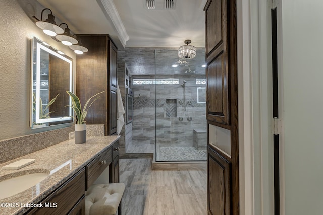 4517 9th St, Lubbock, TX 79416 - bathroom featuring a stall shower, vanity, crown molding, a chandelier, and plenty of natural light