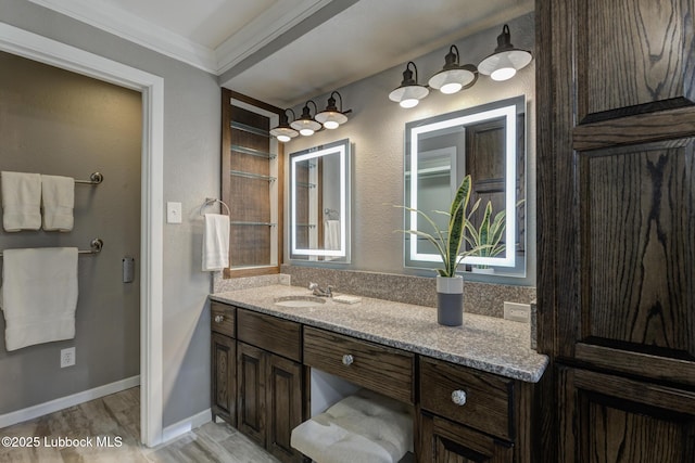4517 9th St, Lubbock, TX 79416 - bathroom with ornamental molding, vanity, wood finished floors, and baseboards