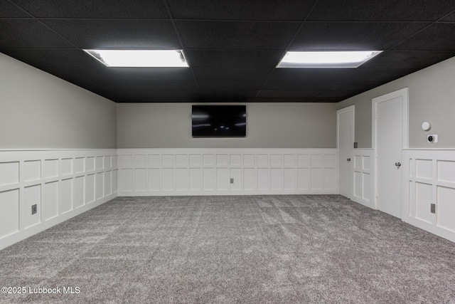 4517 9th St, Lubbock, TX 79416 - carpeted empty room featuring a drop ceiling, wainscoting, and a decorative wall