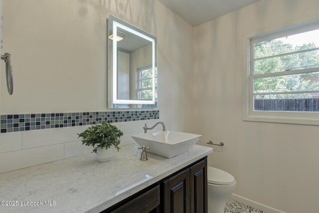 4517 9th St, Lubbock, TX 79416 - bathroom with plenty of natural light, vanity, toilet, and baseboards