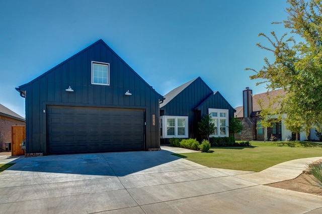 modern inspired farmhouse featuring board and batten siding, a front yard, driveway, and a garage