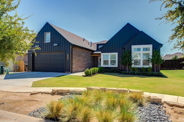 modern farmhouse style home with brick siding, concrete driveway, board and batten siding, fence, and a front lawn