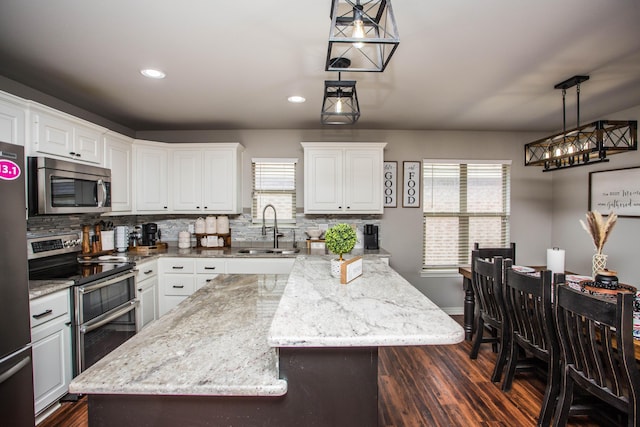 2911 111th St, Lubbock, TX 79423 - kitchen featuring stainless steel appliances, dark wood-style flooring, tasteful backsplash, white cabinets, and recessed lighting