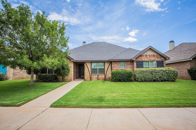 2911 111th St, Lubbock, TX 79423 - view of front of property featuring a front yard, roof with shingles, brick siding, and stone siding