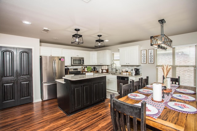 2911 111th St, Lubbock, TX 79423 - kitchen featuring appliances with stainless steel finishes, a kitchen island, white cabinets, backsplash, and recessed lighting