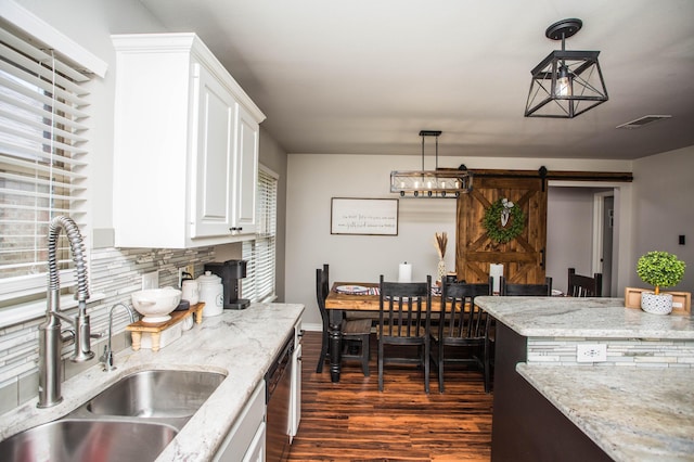2911 111th St, Lubbock, TX 79423 - kitchen with dark wood-style floors, tasteful backsplash, white cabinetry, dishwashing machine, and light stone countertops