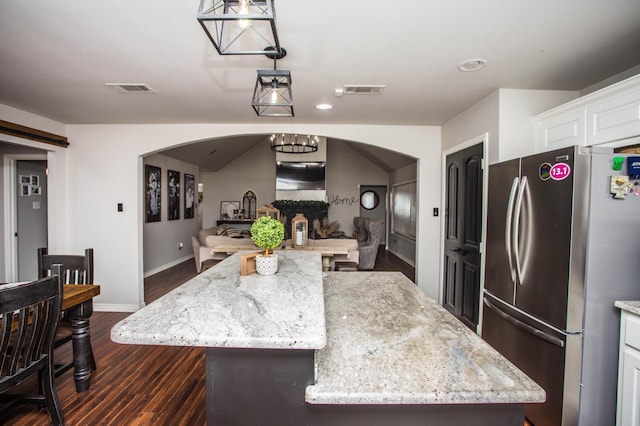 2911 111th St, Lubbock, TX 79423 - kitchen featuring freestanding refrigerator, arched walkways, dark wood finished floors, white cabinets, and open floor plan