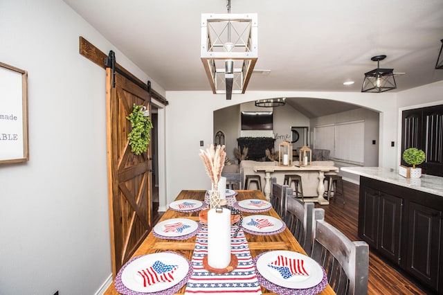 2911 111th St, Lubbock, TX 79423 - dining space featuring a barn door, wood finished floors, and arched walkways