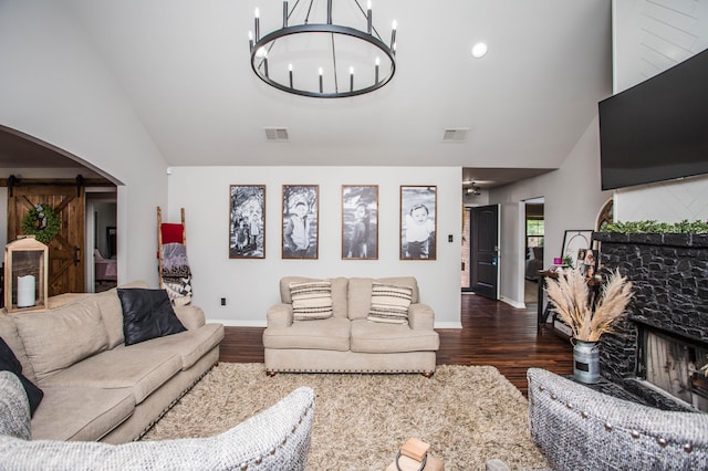 2911 111th St, Lubbock, TX 79423 - living room featuring a barn door, wood finished floors, a chandelier, high vaulted ceiling, and arched walkways