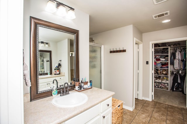 2911 111th St, Lubbock, TX 79423 - bathroom with a shower stall, a spacious closet, vanity, and tile patterned flooring