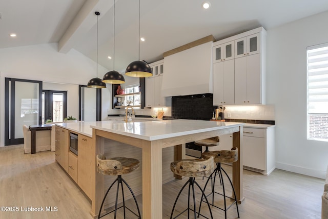 3817 128th St, Lubbock, TX 79423 - kitchen featuring stainless steel microwave, a large island, tasteful backsplash, light wood-style flooring, and recessed lighting