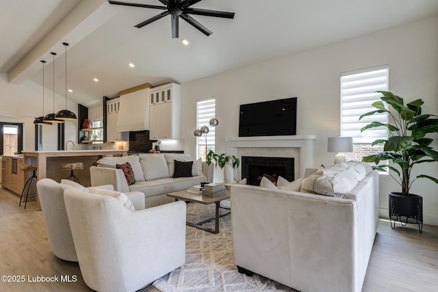 3817 128th St, Lubbock, TX 79423 - living area featuring light wood finished floors, ceiling fan, a brick fireplace, and recessed lighting