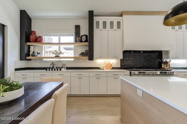 3817 128th St, Lubbock, TX 79423 - kitchen featuring open shelves, decorative backsplash, light wood-style floors, stainless steel range, and white cabinetry