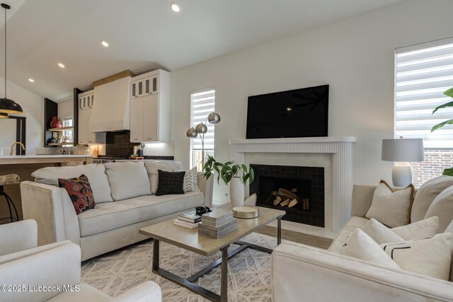 3817 128th St, Lubbock, TX 79423 - living area featuring a fireplace with flush hearth, recessed lighting, lofted ceiling, and light wood-type flooring