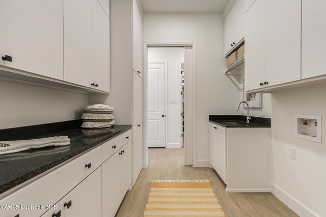 3817 128th St, Lubbock, TX 79423 - laundry area with light wood-style flooring, hookup for a washing machine, and cabinet space