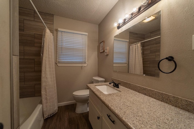 full bathroom featuring hardwood / wood-style flooring, vanity, shower / tub combo, toilet, and a textured ceiling