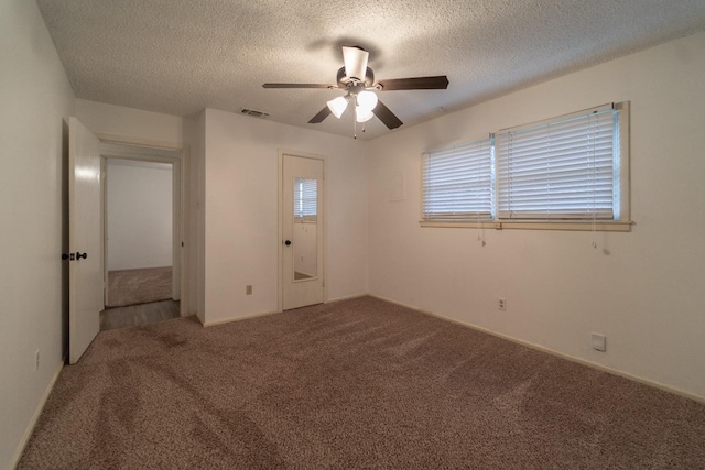 carpeted spare room with ceiling fan and a textured ceiling