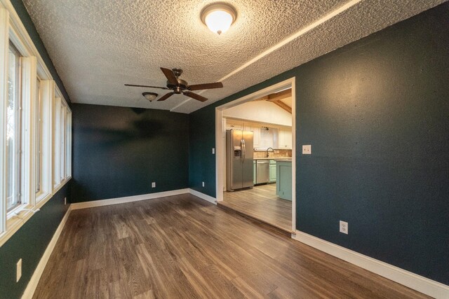 unfurnished room featuring wood-type flooring, sink, ceiling fan, and a textured ceiling