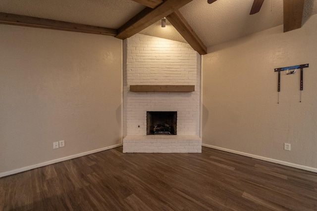 unfurnished living room featuring a brick fireplace, beam ceiling, dark hardwood / wood-style floors, and a textured ceiling