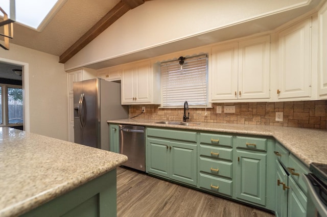 kitchen featuring vaulted ceiling, dark hardwood / wood-style floors, sink, white cabinets, and stainless steel appliances