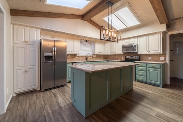 kitchen with sink, a center island, hanging light fixtures, stainless steel appliances, and white cabinets