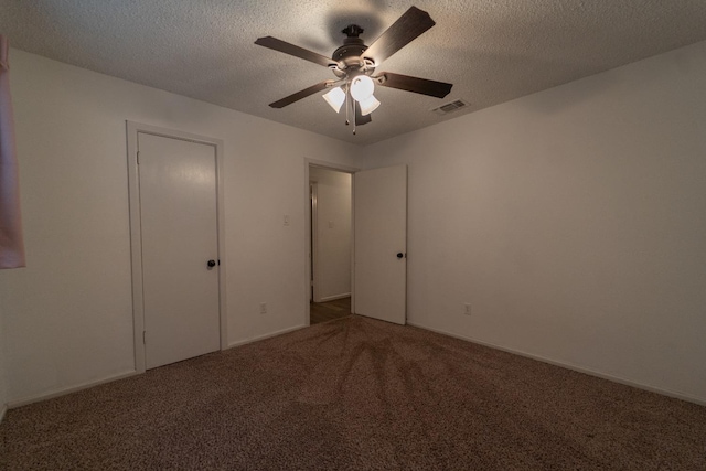 unfurnished bedroom featuring ceiling fan, a textured ceiling, and carpet flooring