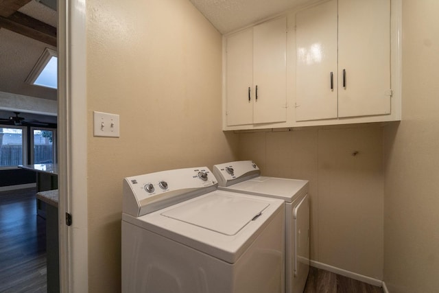 clothes washing area featuring cabinets, dark hardwood / wood-style floors, washer and clothes dryer, and a textured ceiling