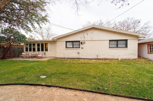 rear view of house featuring a yard and a patio