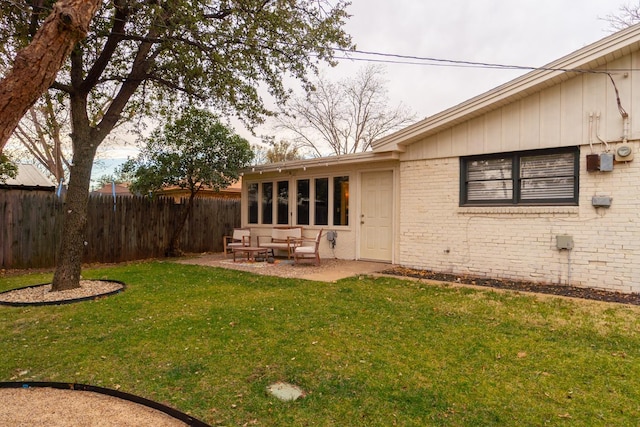 back of house with a lawn and a patio area