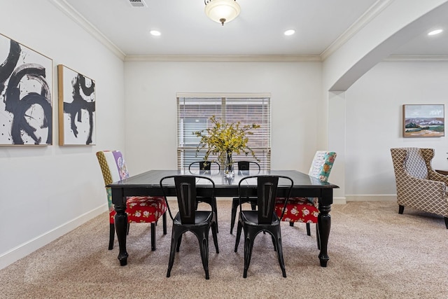 carpeted dining area with ornamental molding