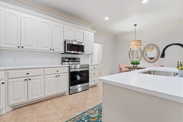 kitchen with sink, white cabinetry, hanging light fixtures, stainless steel appliances, and ornamental molding