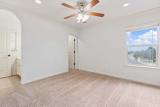 carpeted empty room featuring ornamental molding and ceiling fan