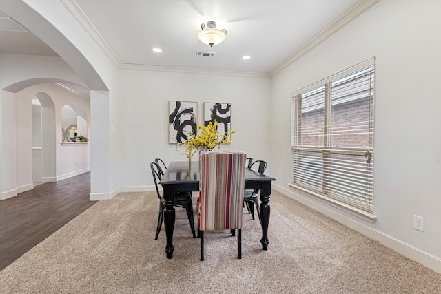 carpeted dining room featuring ornamental molding