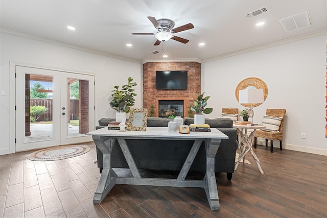 living room featuring ornamental molding, a brick fireplace, ceiling fan, and french doors