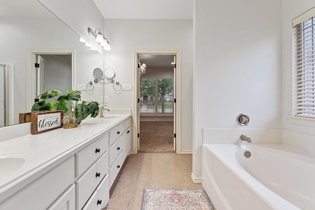 bathroom featuring plenty of natural light, a bathing tub, tile patterned flooring, and vanity