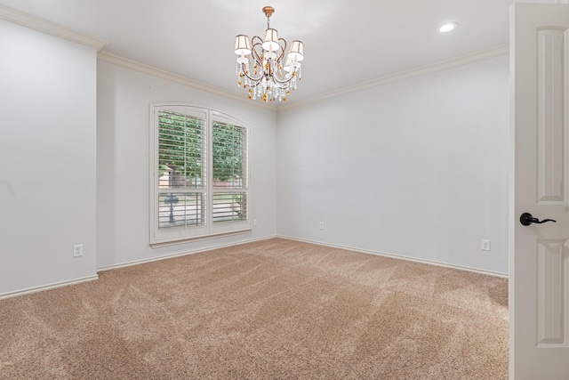 carpeted spare room featuring ornamental molding and a chandelier