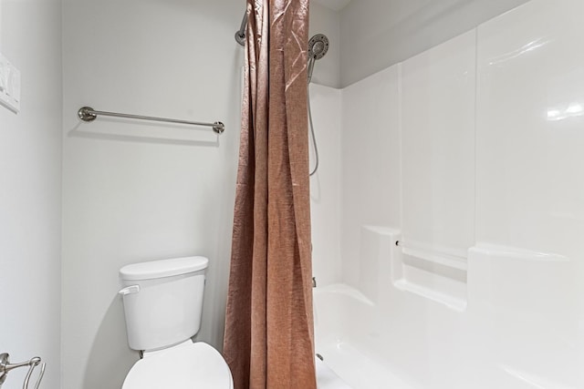 bathroom featuring curtained shower and toilet