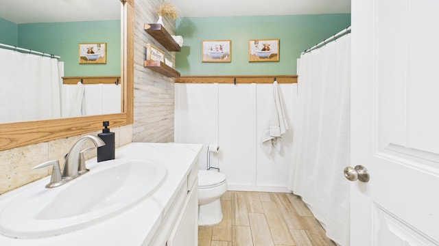 bathroom with toilet, wood finished floors, and vanity