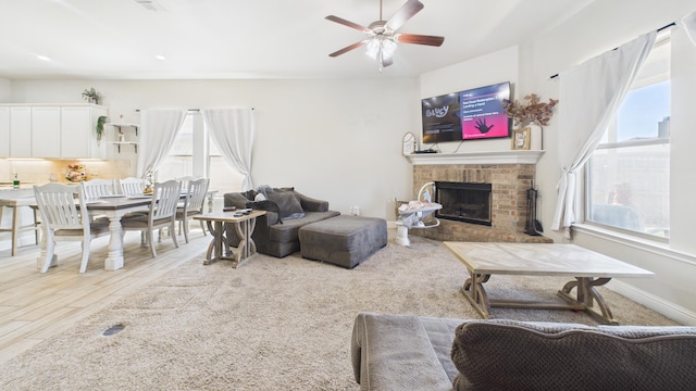 living area with a fireplace and a ceiling fan