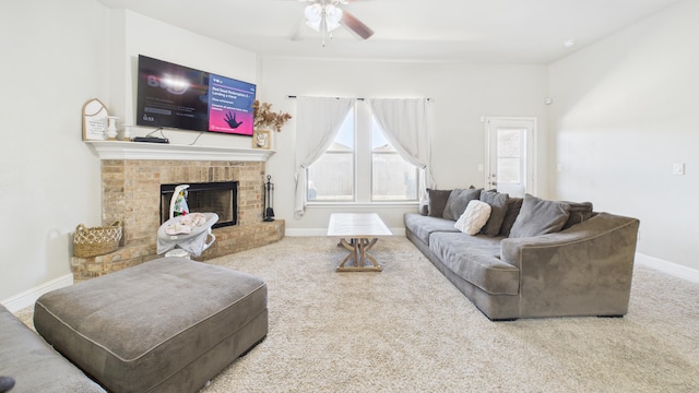 living area featuring a brick fireplace, a ceiling fan, carpet, and baseboards