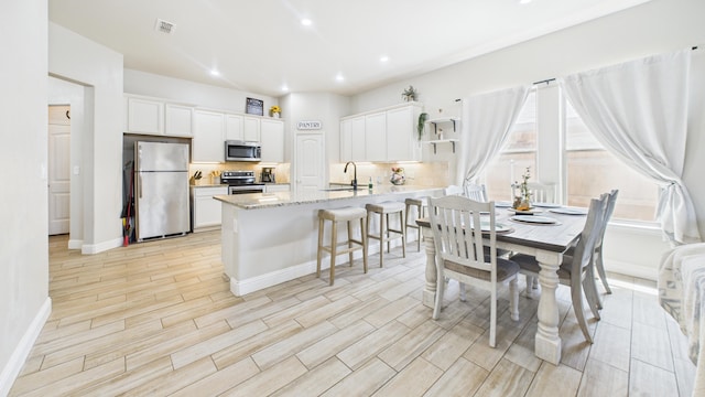 dining space with baseboards, visible vents, light wood-style floors, and recessed lighting