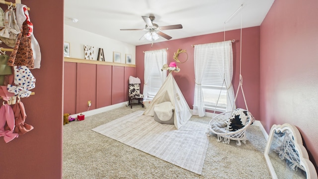 recreation room with a ceiling fan and carpet flooring