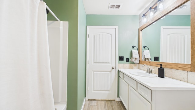 bathroom featuring visible vents, wood finished floors, and vanity