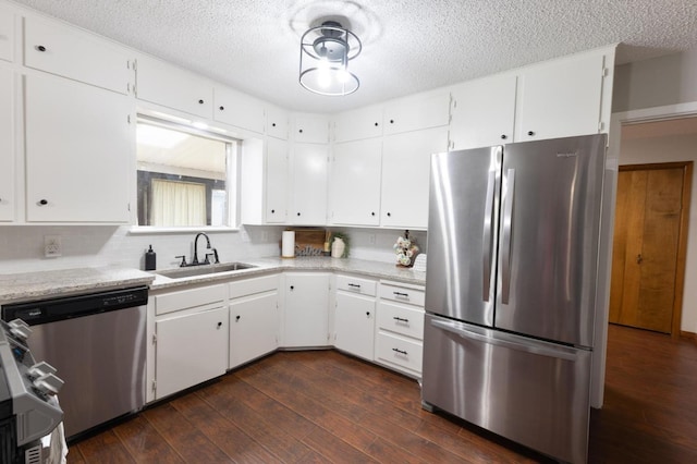 kitchen with dark wood-type flooring, sink, stainless steel appliances, decorative backsplash, and white cabinets