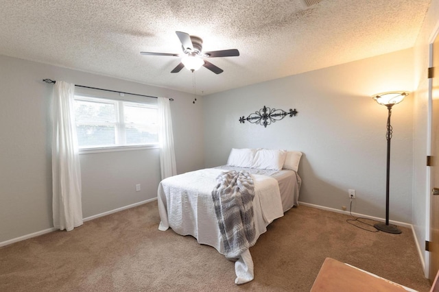 bedroom with ceiling fan, carpet, and a textured ceiling