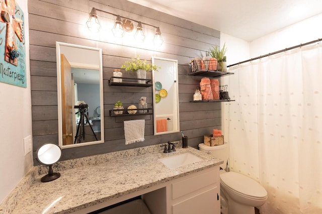 bathroom with wood walls, a shower with shower curtain, toilet, and vanity