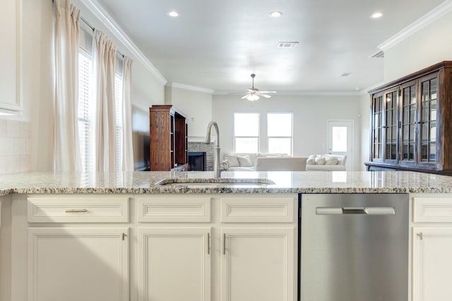 kitchen with sink, crown molding, light stone counters, white cabinets, and stainless steel dishwasher