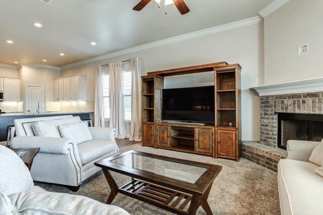 living room with ornamental molding, light colored carpet, ceiling fan, and a fireplace