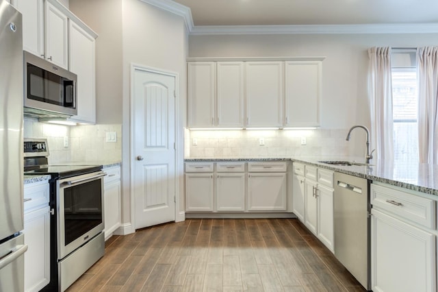 kitchen featuring white cabinetry, appliances with stainless steel finishes, light stone countertops, and sink