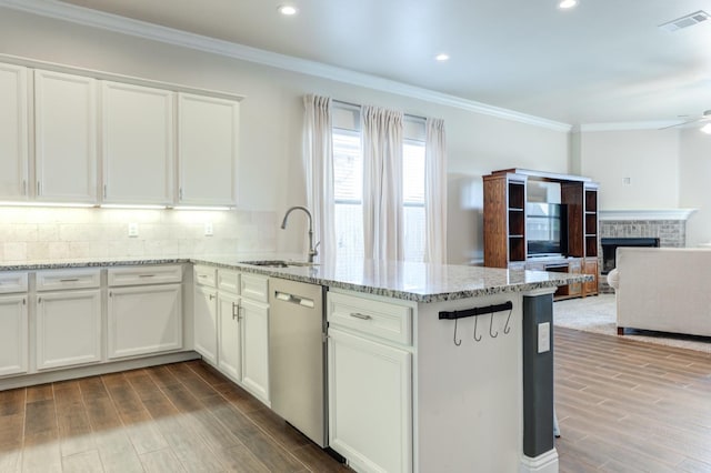 kitchen with light stone countertops, sink, stainless steel dishwasher, and white cabinets